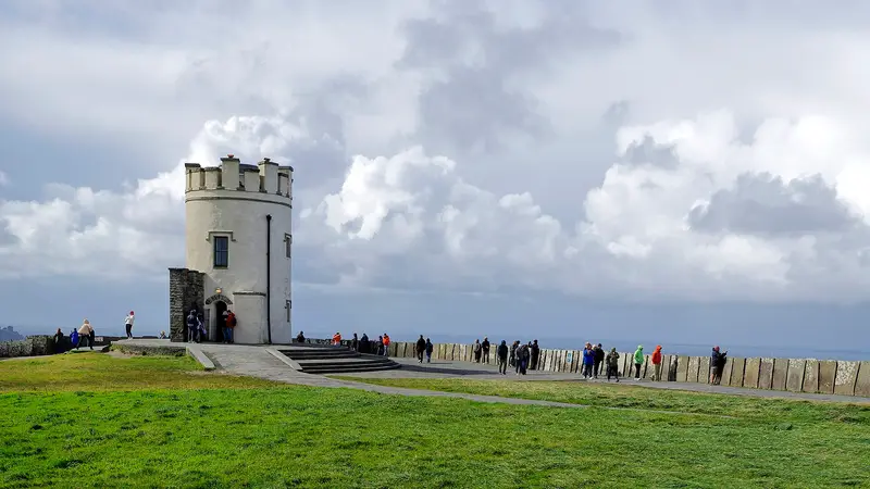 O'Brien's Tower on the cliff top, with visitors along the path beside it