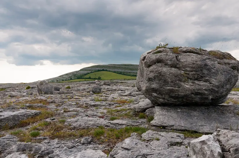 A limestone boulder resting on bare limestone pavement in the Burren